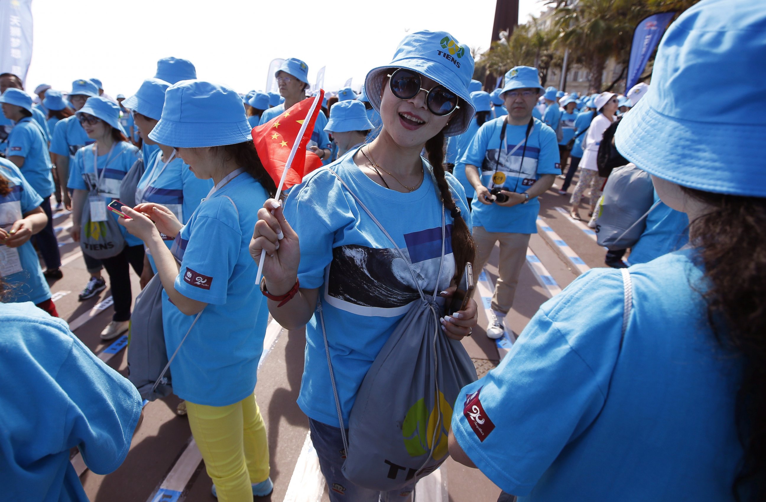 PHOTO: Employees of the Chinese company 'Tiens' attend a parade on May 8, 2015 in Nice, France.