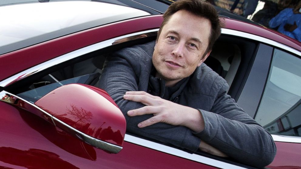 Elon Musk, co-founder and CEO of Tesla Motors, poses with a Tesla during a visit to Amsterdam on January 31, 2014.