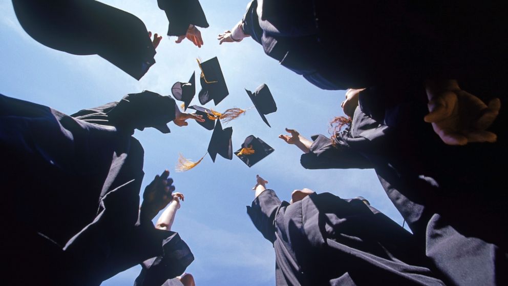 Graduates throw their caps in the air in an undated stock photo.