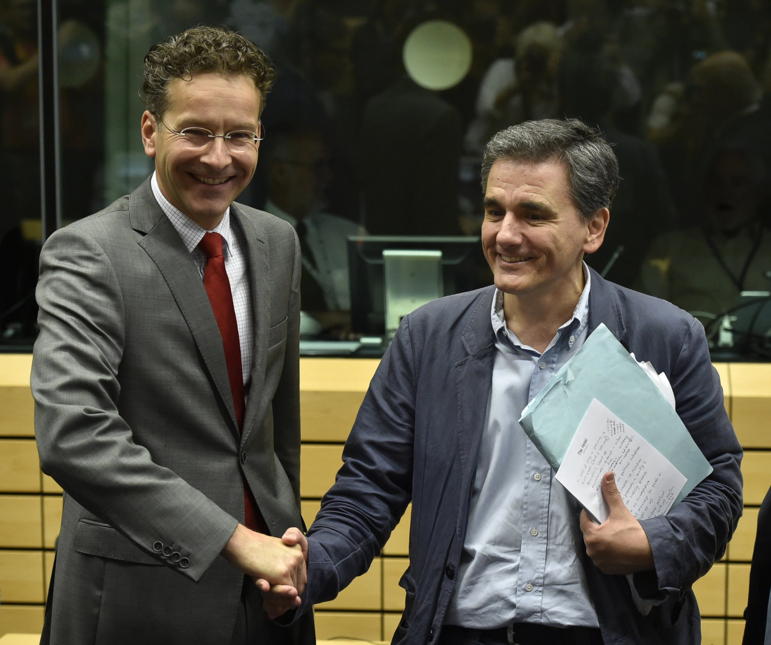 PHOTO: Dutch Finance Minister and president of the Eurogroup Jeroen Dijsselbloem (L) shakes hands with newly appointed Greek Finance Minister Euclid Tsakalotos during a Eurogroup meeting  in Brussels on July 7, 2015. 