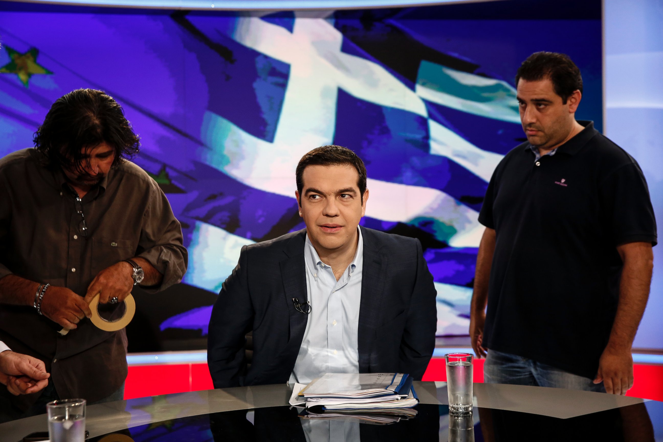 PHOTO: Alexis Tsipras, Greece's prime minister, center, takes his seat for a televised interview in Athens, Greece, June 29, 2015. 