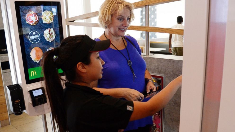 PHOTO: McDonalds worker Jacqueline Garcia helps a customer order a custom meal from the the Create Your Taste kiosk at special McDonalds restaurant in Aurora, Colo., Aug. 26, 2015.