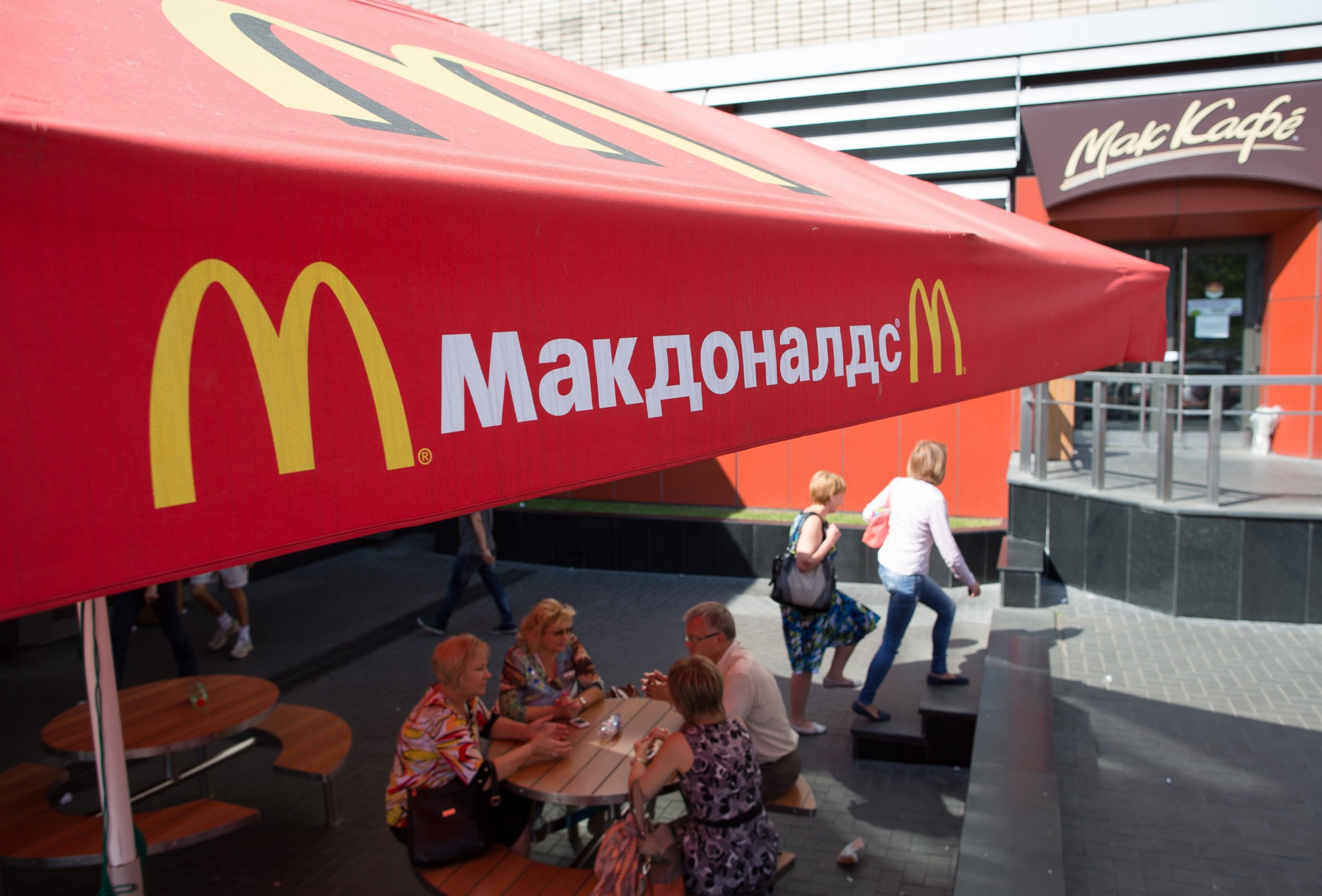 PHOTO: Pedestrians sit at outdoor tables beneath McDonald's parasols on Pushkin Square in Moscow, Russia, Aug. 21, 2014.
