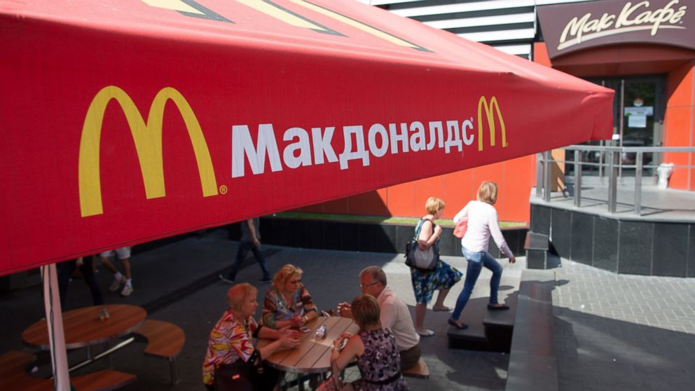 PHOTO: Pedestrians sit at outdoor tables beneath McDonald's parasols on Pushkin Square in Moscow, Russia, Aug. 21, 2014.