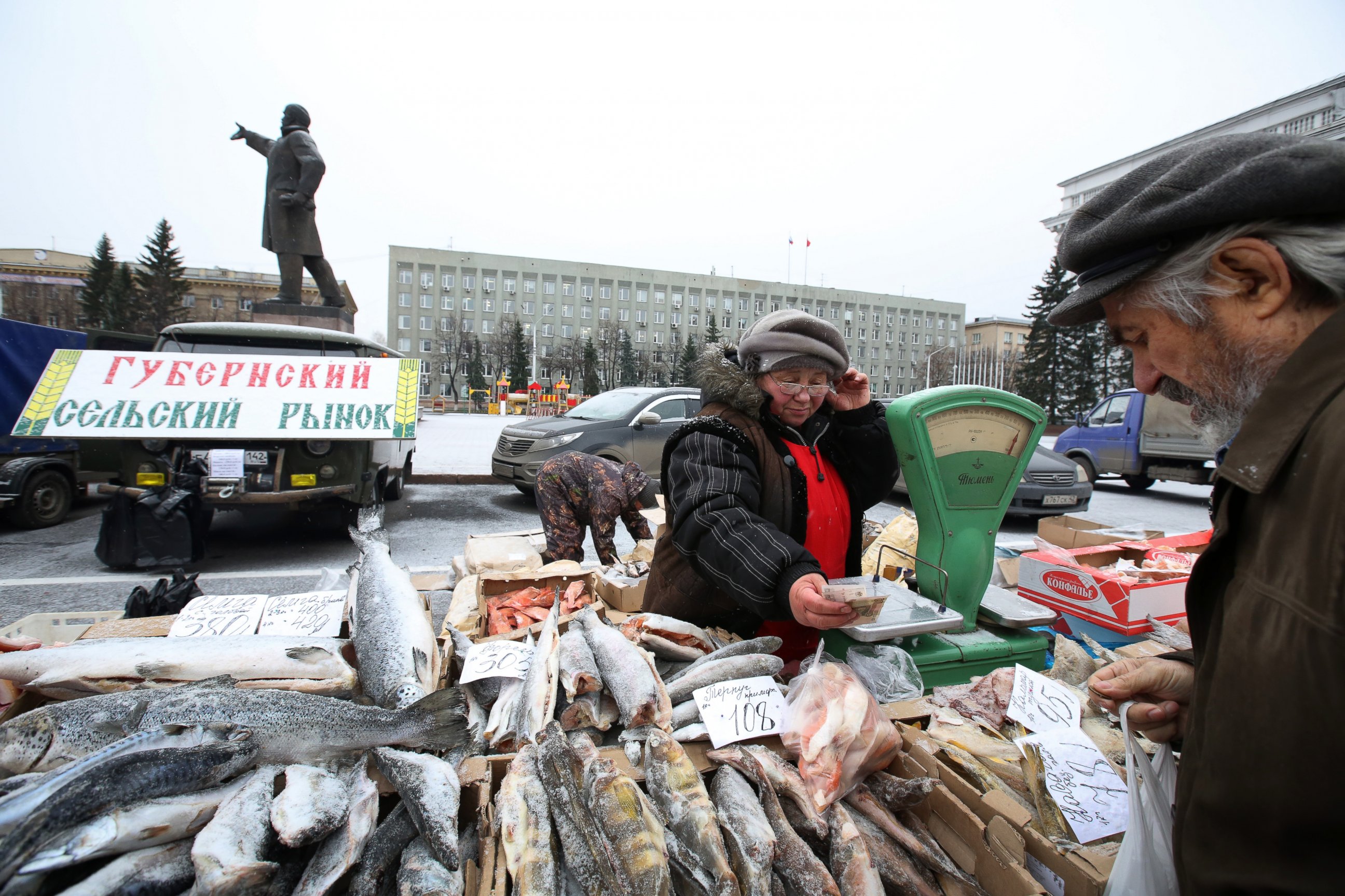 PHOTO: A statue of Vladimir Lenin stands in a central square near a monthly street market where a vendor sells fresh fish in Sovetov square, Kemerovo, Russia, Oct. 24, 2014.
