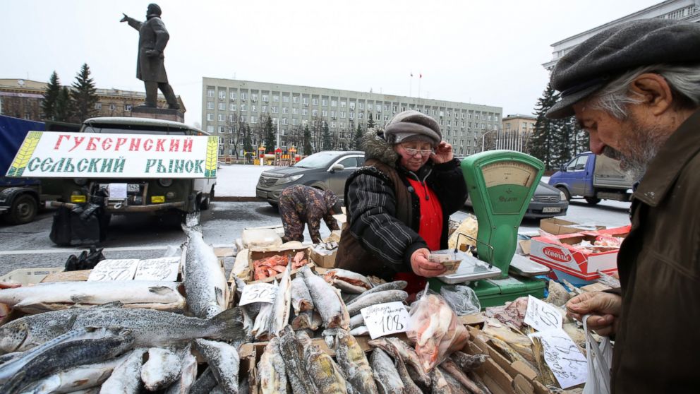 PHOTO: A statue of Vladimir Lenin stands in a central square near a monthly street market where a vendor sells fresh fish in Sovetov square, Kemerovo, Russia, Oct. 24, 2014.