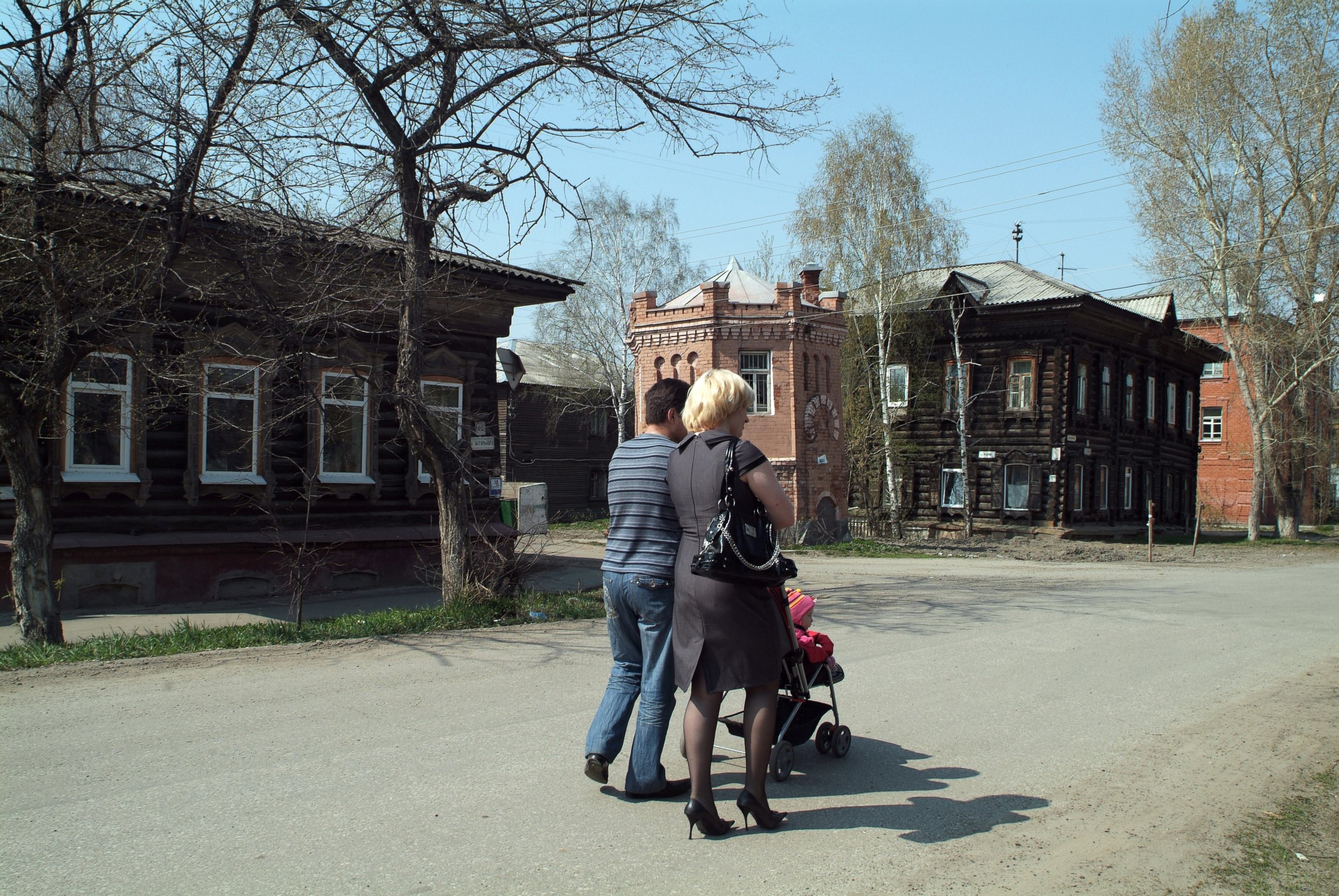 PHOTO: A couple walk past old wooden house in the Siberian town of Tomsk, Oct. 5, 2009.