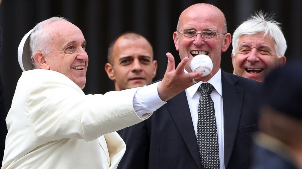 Pope Francis loses his 'papalina' cup as he reaches to catch a baseball ball thrown by a faithful at the end of his weekly audience at St. Peter's Square on Sept. 24, 2014 in Vatican City, Vatican.