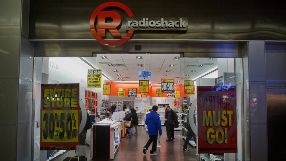 Sale signs are displayed as customers browse inside a RadioShack Corp. store that is closing in New York on Feb. 25, 2014.