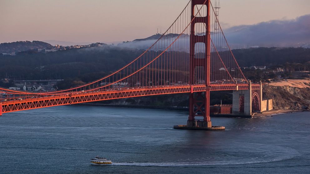 A tour boat travels under the Golden Gate Bridge as viewed from the Marin Headlands on Oct. 20, 2013, in San Francisco, Calif. 