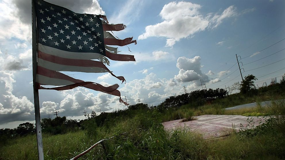 A tattered American flag flies over the slab of a former home in New Orleans, Aug. 17, 2007.