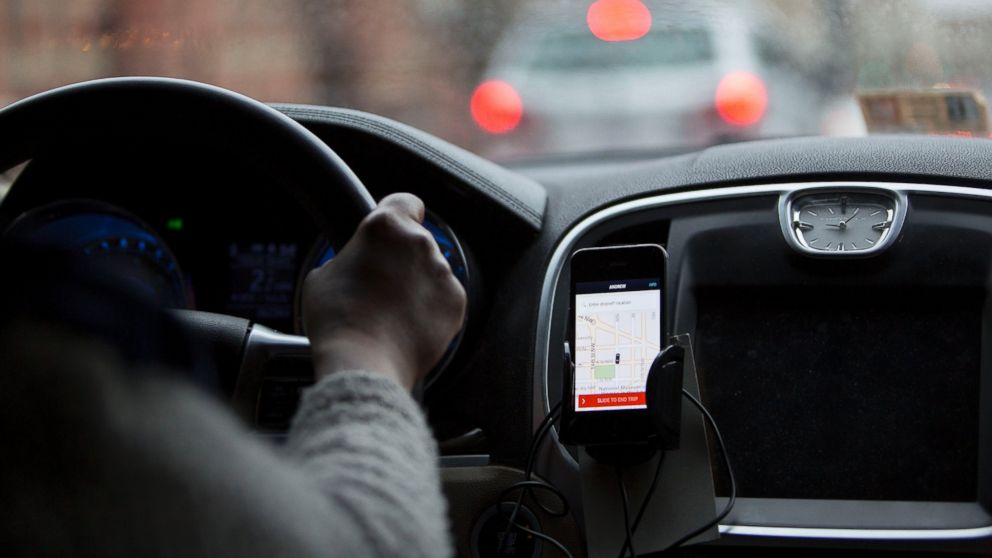 The Uber application runs on a driver's iPhone during an Uber ride in Washington, D.C., April 8, 2015.