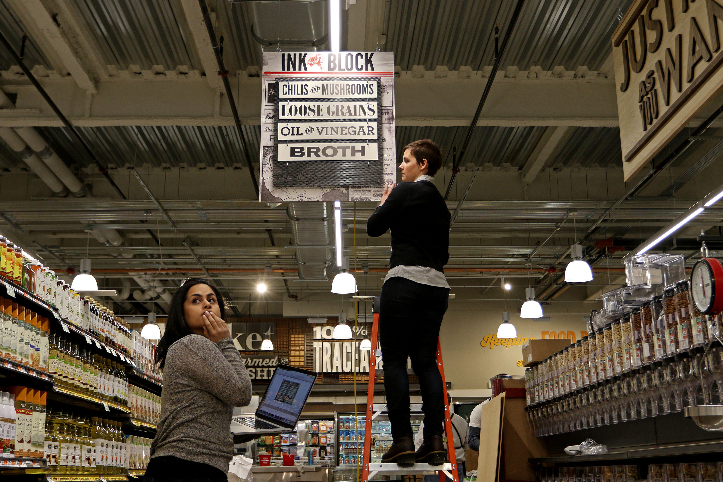 PHOTO: Two employees puts up signage at a new Whole Foods Market in the South End neighborhood of Boston, Mass. on Jan. 6, 2015.