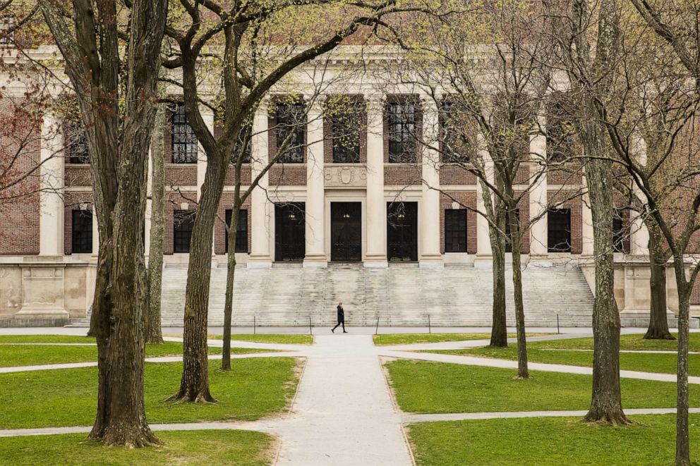 PHOTO: A pedestrian walks through Harvard Yard on the closed Harvard University campus in Cambridge, Mass., April 20, 2020.