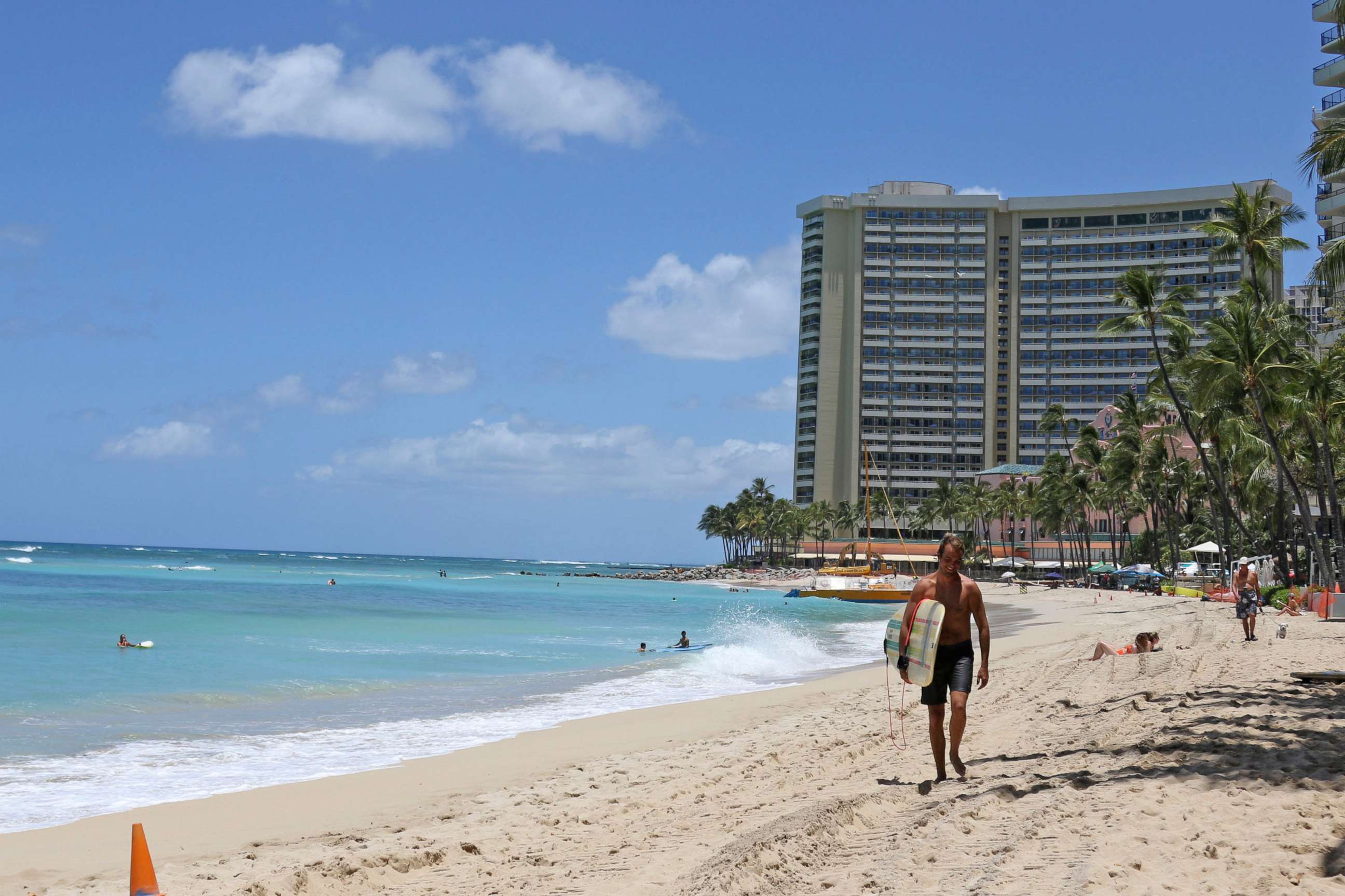 PHOTO: A surfer walks on a sparsely populated Waikiki beach in Honolulu, June 5, 2020.