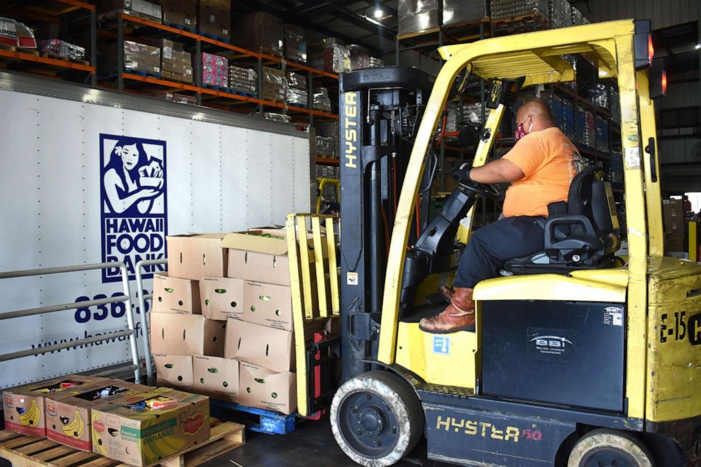 PHOTO: A volunteer at the Hawaii Foodbank distributes food amid the COVID-19 crisis. 