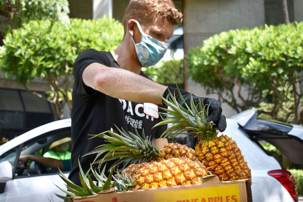 PHOTO: A volunteer at the Hawaii Foodbank distributes food amid the COVID-19 crisis. 
