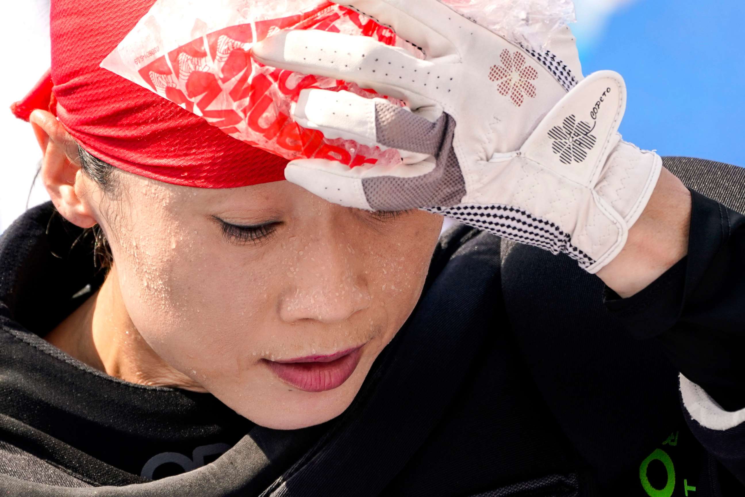 PHOTO: Beads of sweat gather on the face of China women's field hockey goalkeeper Dongxiao Li as she presses a bag of ice against her head during practice hours at the 2020 Summer Olympics, July 23, 2021, in Tokyo.