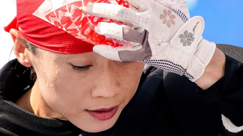 PHOTO: Beads of sweat gather on the face of China women's field hockey goalkeeper Dongxiao Li as she presses a bag of ice against her head during practice hours at the 2020 Summer Olympics, July 23, 2021, in Tokyo.