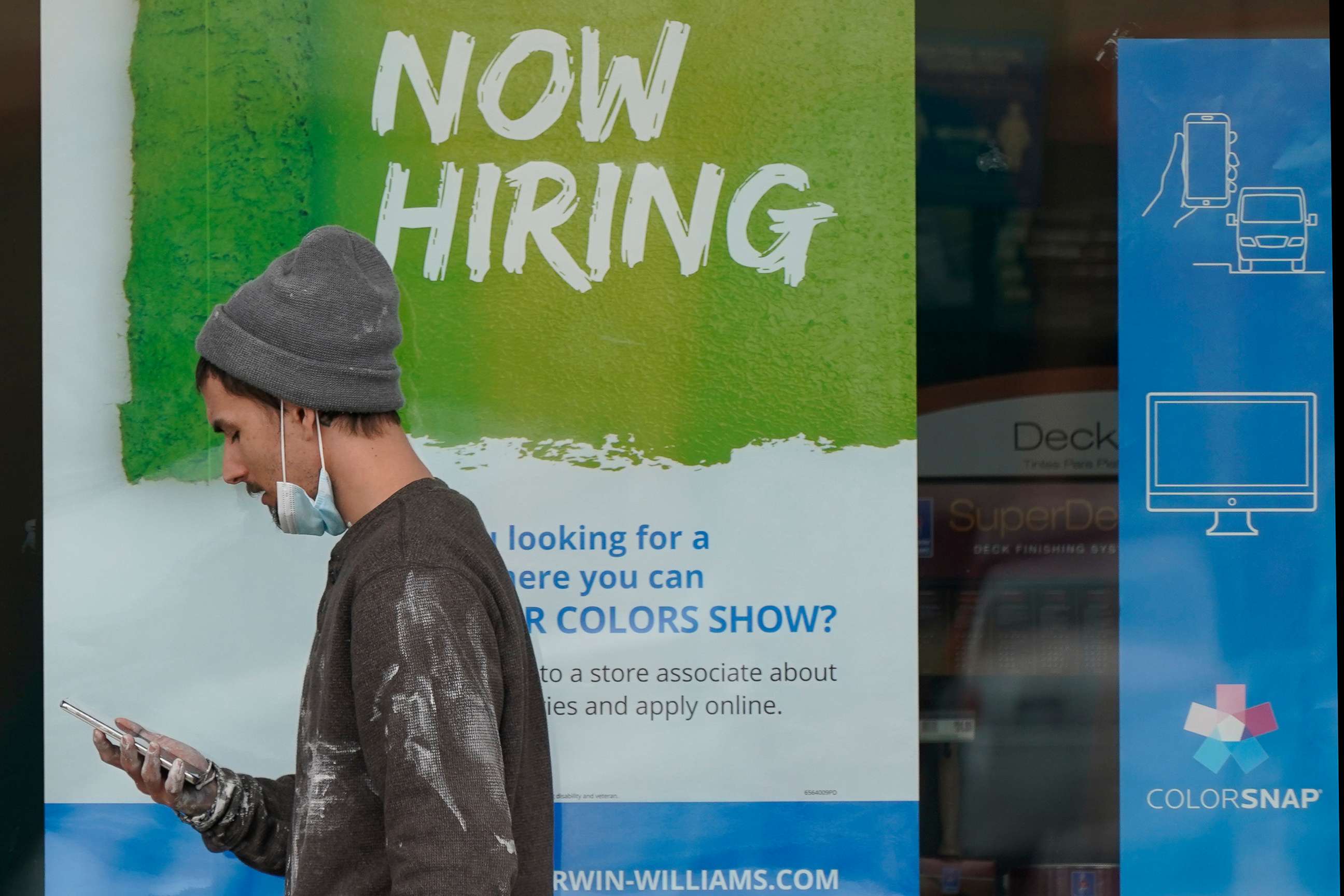 PHOTO: A man walks past a "Now Hiring" sign on a window at Sherwin Williams store, Feb. 26, 2021, in Woodmere Village, Ohio.
