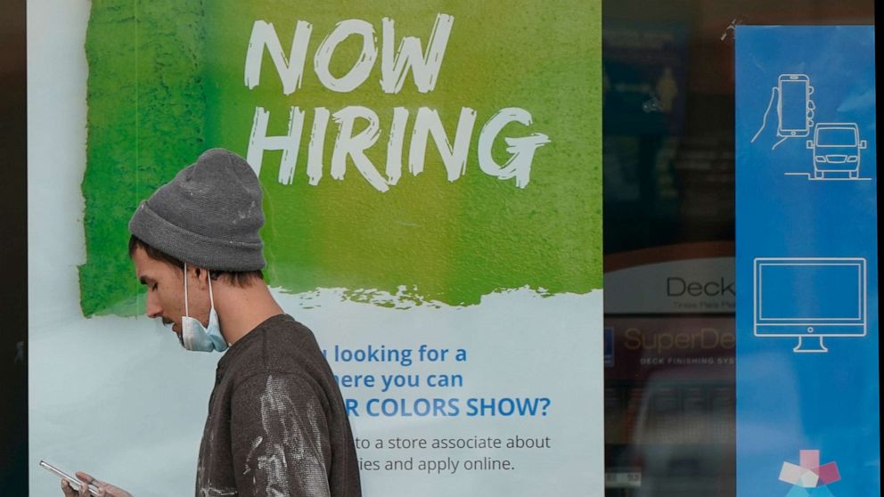 PHOTO: A man walks past a "Now Hiring" sign on a window at Sherwin Williams store, Feb. 26, 2021, in Woodmere Village, Ohio.