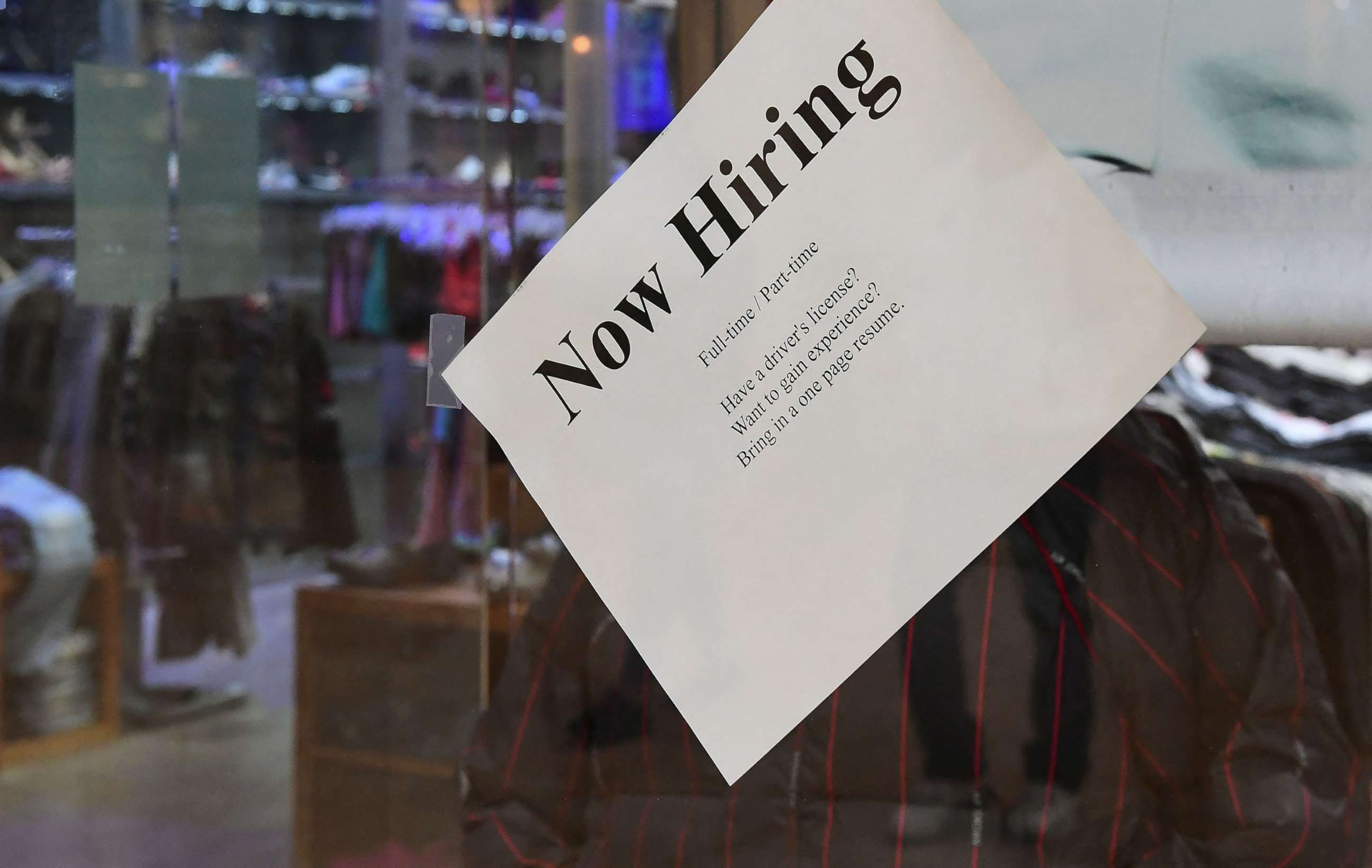 PHOTO: A "Now Hiring" sign is placed on the glass store front of a store in Montebello, Calif., Dec 9, 2021.