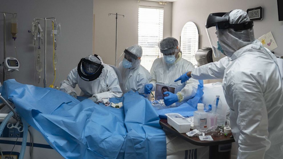PHOTO: Doctors and nurses wearing protective gear treat a patient in the Covid-19 intensive care unit (ICU) at the United Memorial Medical Center (UMMC) in Houston, Texas on June 29, 2020.