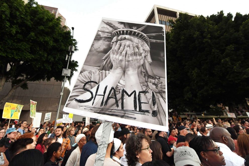 PHOTO: People protest against the upcoming ICE raids and detentions of refugee asylum seekers at a vigil outside the main ICE detention center (background) in downtown Los Angeles, July 12, 2019.