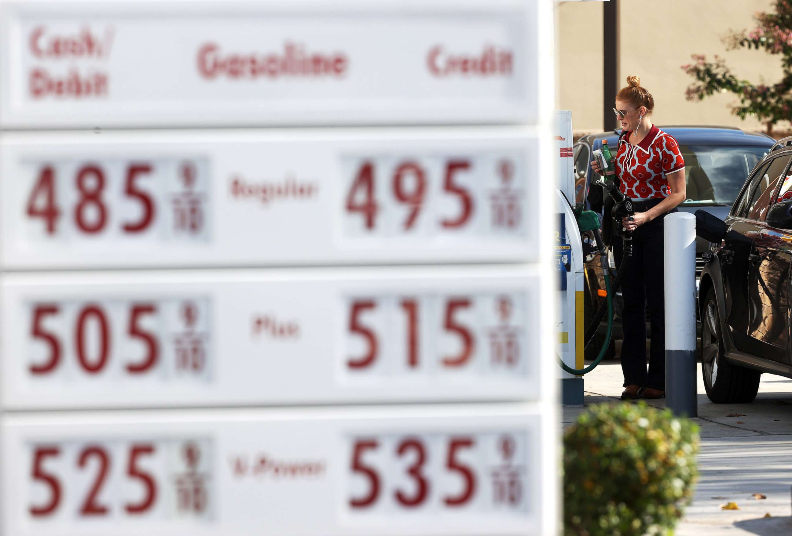 PHOTO: A customer prepares to pump gas into her car at a station in  San Rafael, Calif., Nov. 17, 2021. 