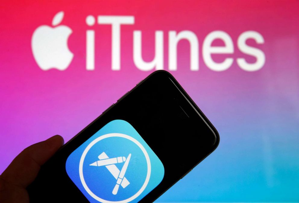 PHOTO: In this photo illustration, the App Store logo is displayed on the screen of a mobile phone in front of a computer screen displaying  the logo of the multimedia application iTunes on June 3, 2019 in Paris