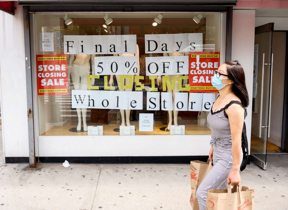 PHOTO: A person walks by a going out of business sign displayed outside a retail store in Murray Hill area of New York as the city continues Phase 4 of re-opening, Sept. 26, 2020.