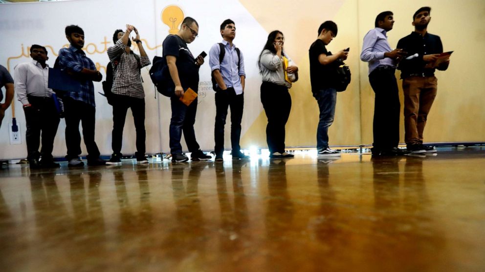 PHOTO: In this Sept. 17, 2019, photo job seekers line up to speak to recruiters during an Amazon job fair in Dallas.