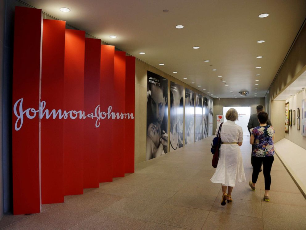 PHOTO: People walk along a corridor at the headquarters of Johnson & Johnson in New Brunswick, N.J., July 30, 2013.