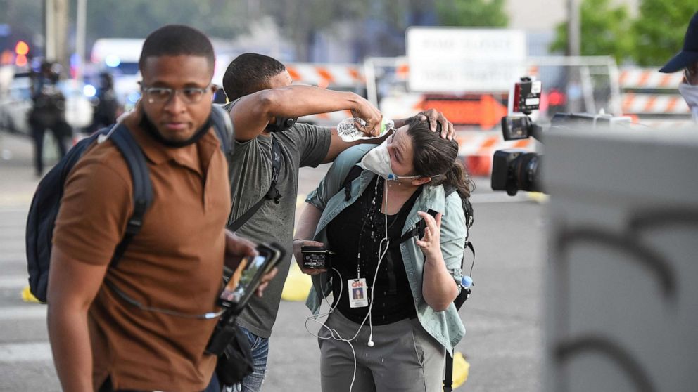 PHOTO: A reporter has her eyes rinsed to clear the effects of tear gas thrown by Minnesota State Troopers as protesters demonstrate during the fifth day of protests in Minneapolis, May 30, 2020.