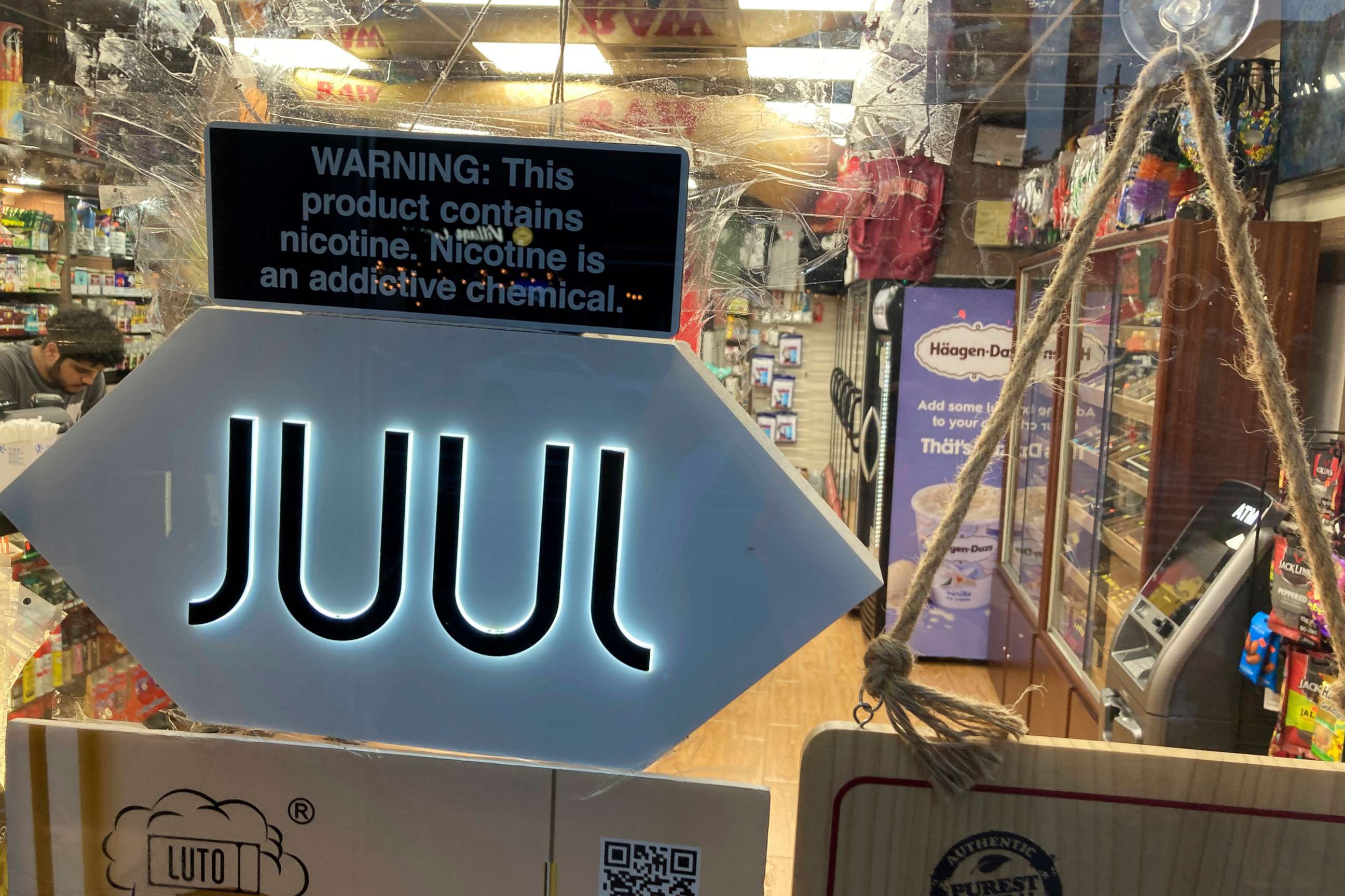 PHOTO: A Juul electronic cigarette sign hangs in the front window of a bodega convenience store in New York City on June 25, 2022.
