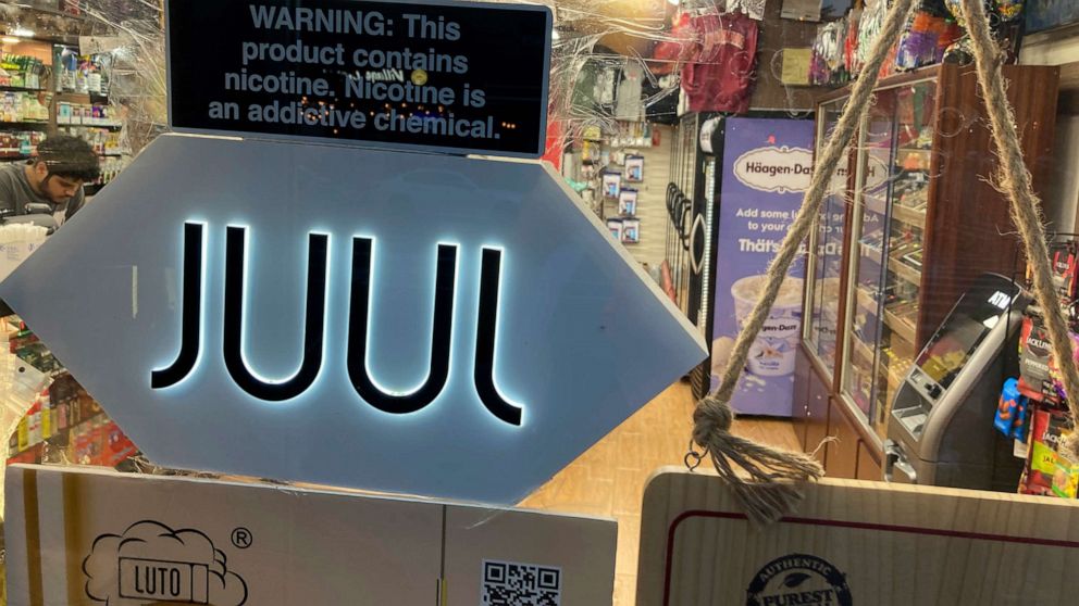 PHOTO: A Juul electronic cigarette sign hangs in the front window of a bodega convenience store in New York City on June 25, 2022.