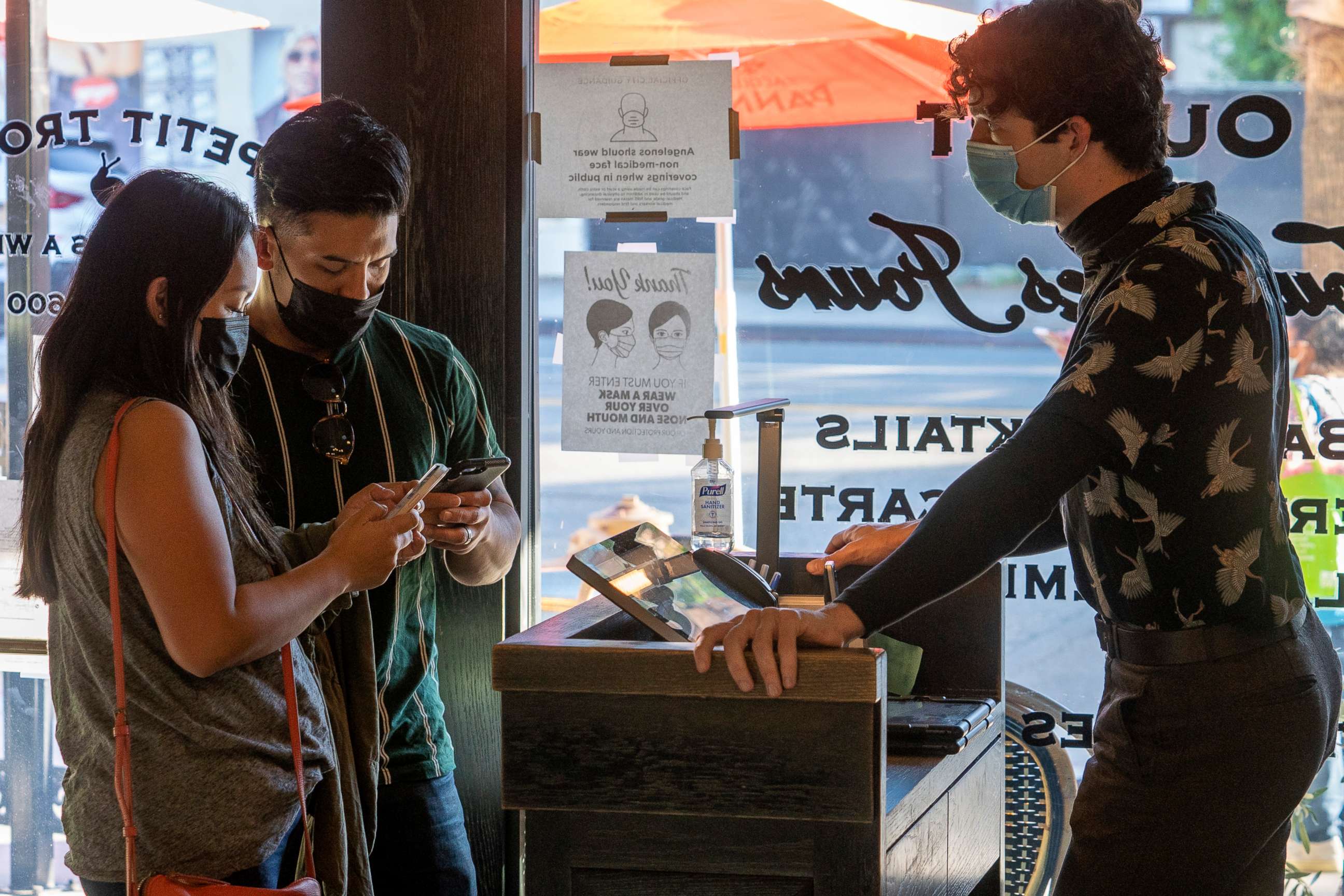 PHOTO: Restaurant host Joey Tyler, right, verifies arriving patrons' Digital COVID-19 Vaccine Records at French restaurant Petit Trois in Los Angeles, Nov. 5, 2021.