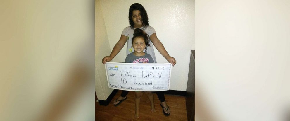 PHOTO: Two of Tiffany Hatfield's three daughters hold her winning lottery check for $10,000.