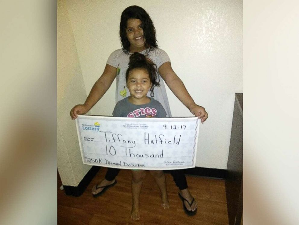 PHOTO: Two of Tiffany Hatfields three daughters hold her winning lottery check for $10,000.