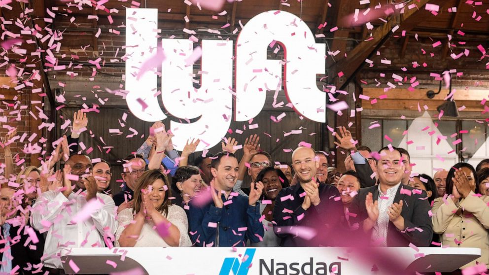 PHOTO: Lyft co-founders John Zimmer, front third from left, and Logan Green, front third from right, cheer as they as they ring a ceremonial opening bell in Los Angeles, March 29, 2019.
