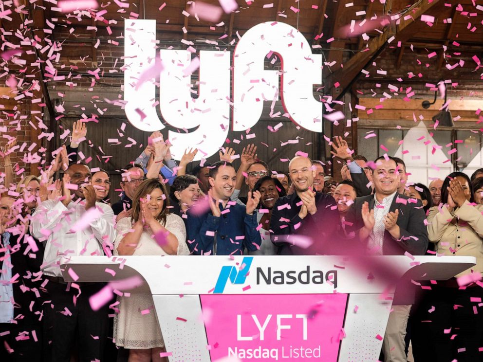 PHOTO: Lyft co-founders John Zimmer, front third from left, and Logan Green, front third from right, cheer as they as they ring a ceremonial opening bell in Los Angeles, March 29, 2019.