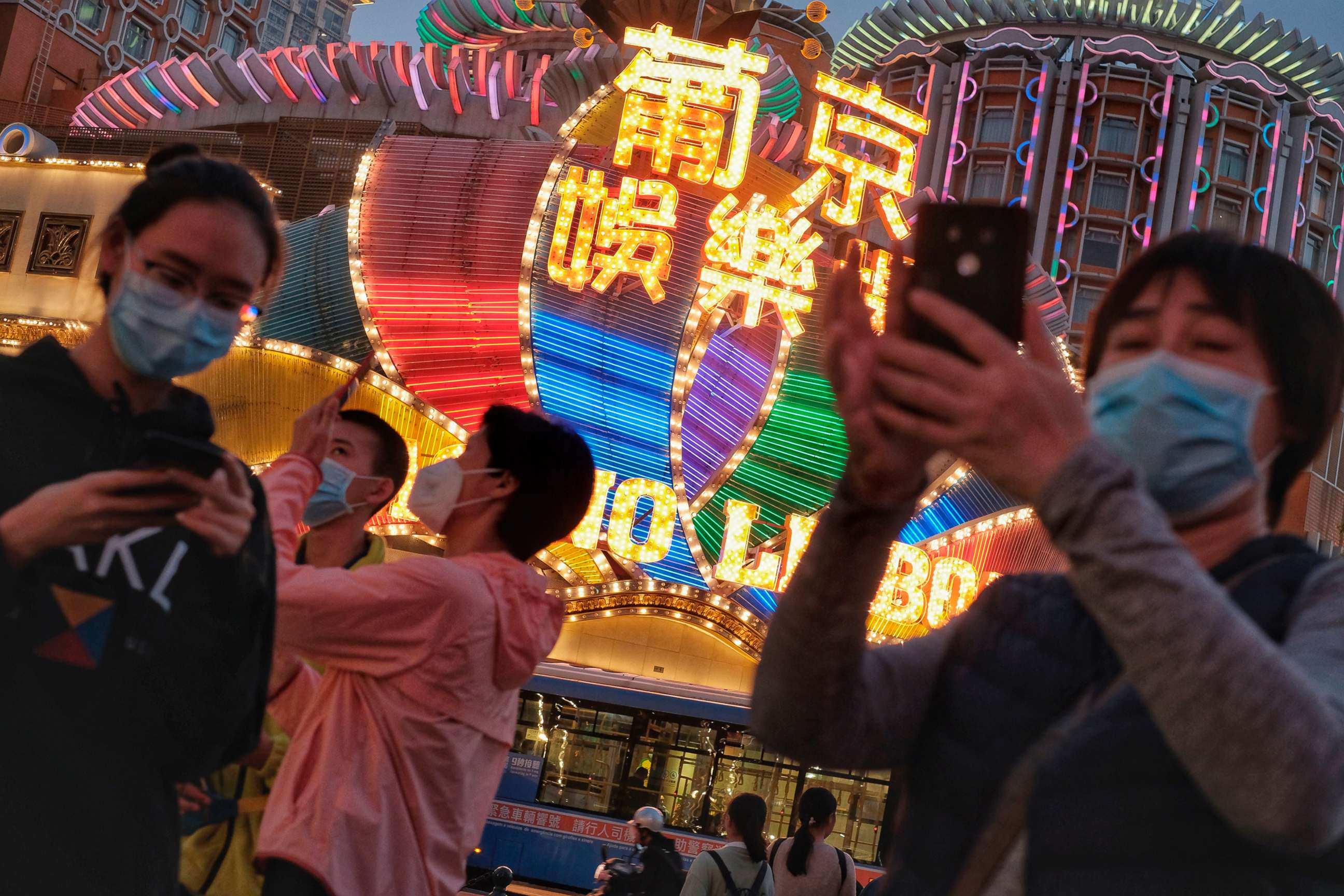 PHOTO: In this Jan, 23, 2020, file photo, released by Initium Media, tourists wearing masks, take photographs outside the Casino Lisboa in Macao, China.