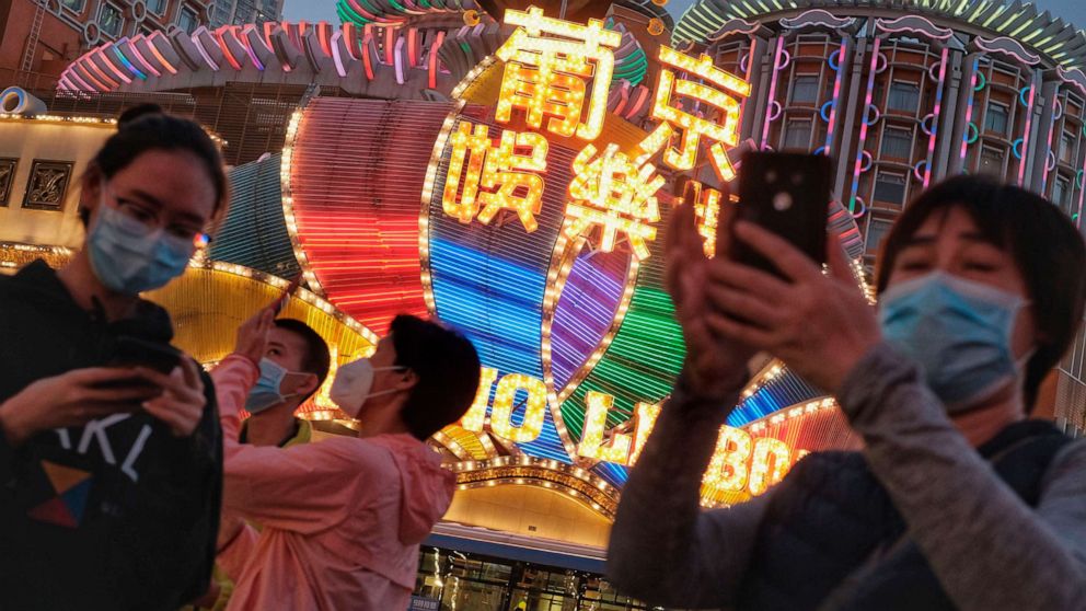 PHOTO: In this Jan, 23, 2020, file photo, released by Initium Media, tourists wearing masks, take photographs outside the Casino Lisboa in Macao, China.