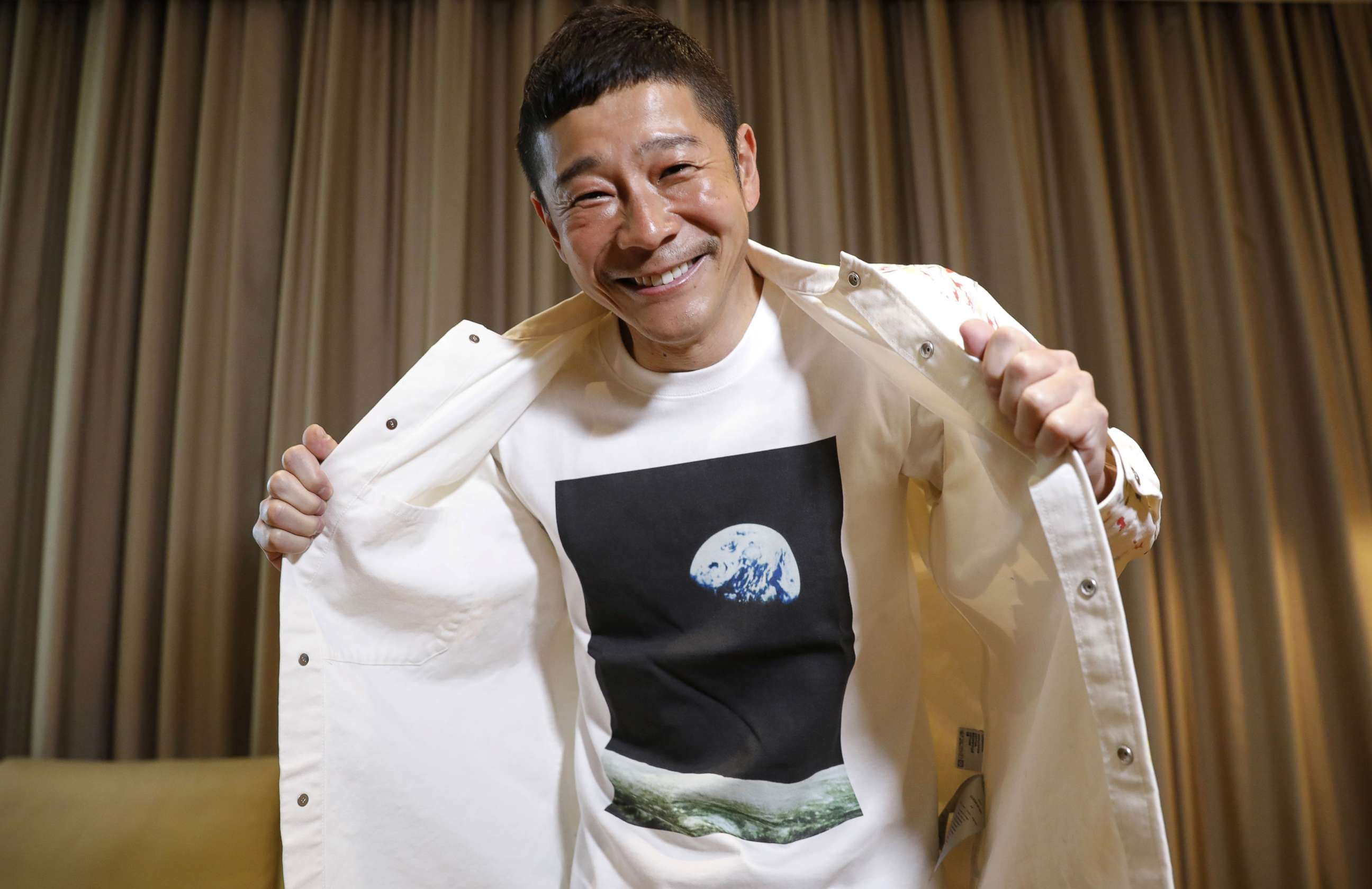 PHOTO: Japanese billionaire Yusaku Maezawa poses with his T-shirt bearing an image of Earth during an interview with Reuters in Tokyo, March 3, 2021.