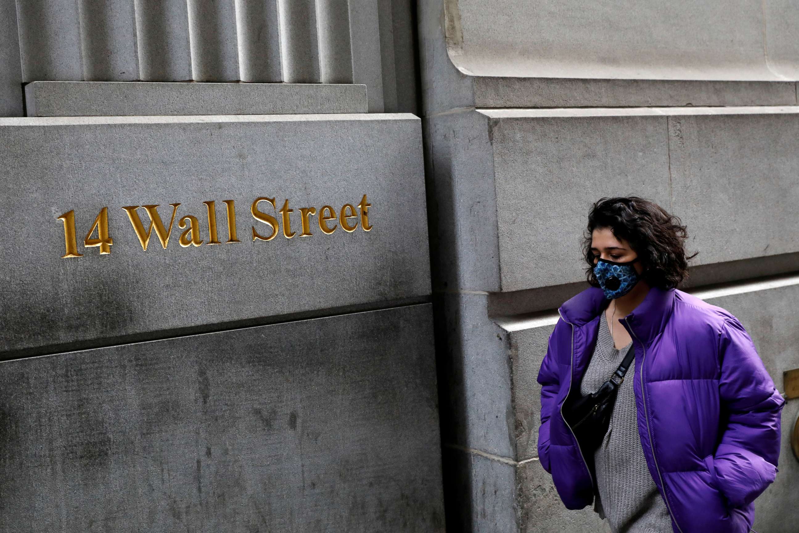 PHOTO: A person wears a face mask walks along Wall Street after further cases of coronavirus were confirmed in New York, March 6, 2020. 