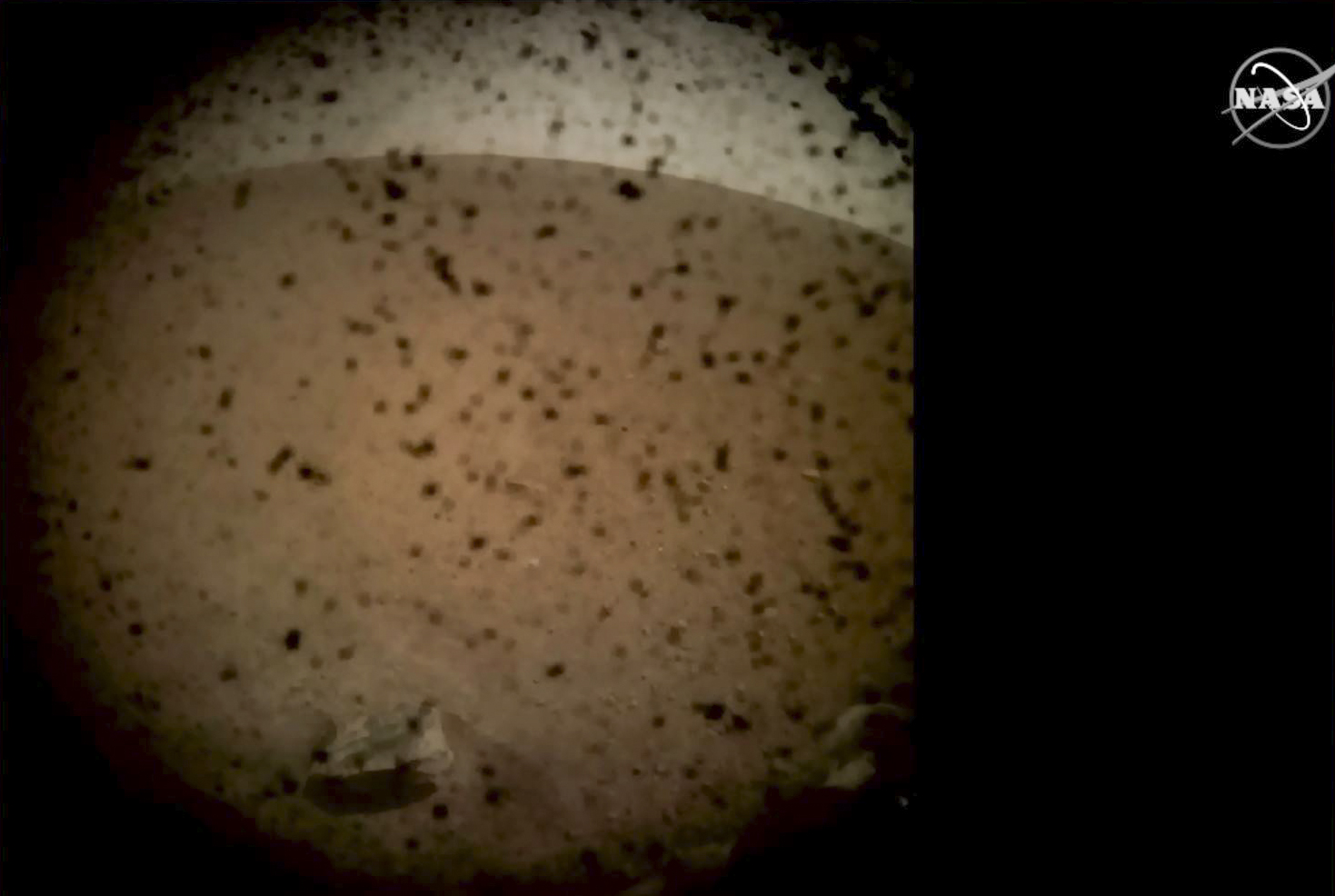 PHOTO: In this frame grab taken from NASA TV on Nov. 26, 2018, debris is seen on the lens in the first image from NASA's InSight lander after it touched down on the surface of Mars.