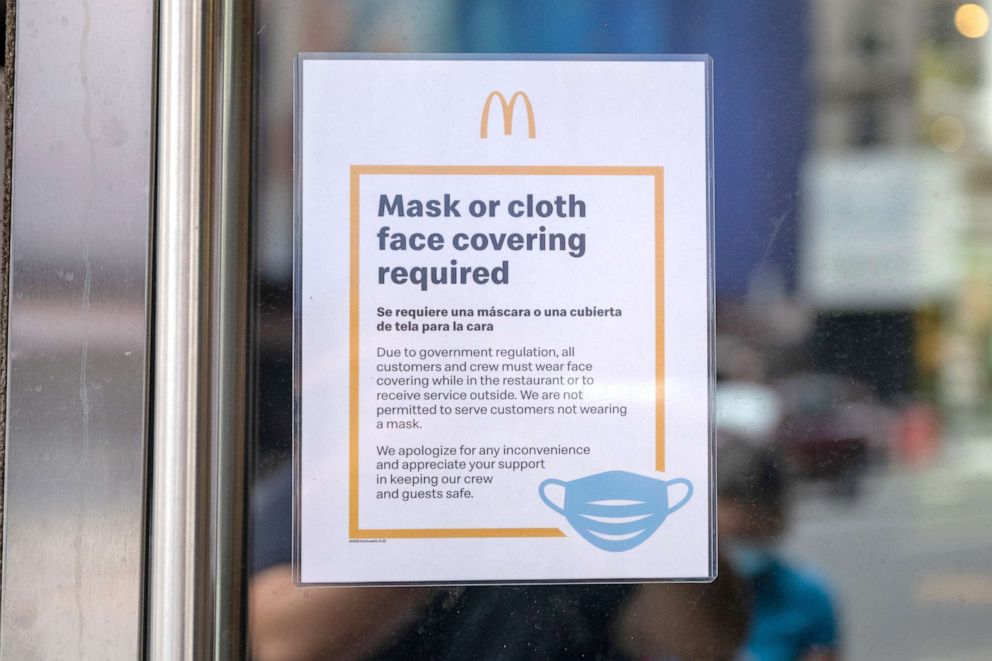 PHOTO: A 'Mask or cloth face covering required' sign is displayed at the entrance of a McDonald's near Times Square as the city continues Phase 4 of re-opening following restrictions imposed to slow the spread of coronavirus, July 24, 2020, in New York.