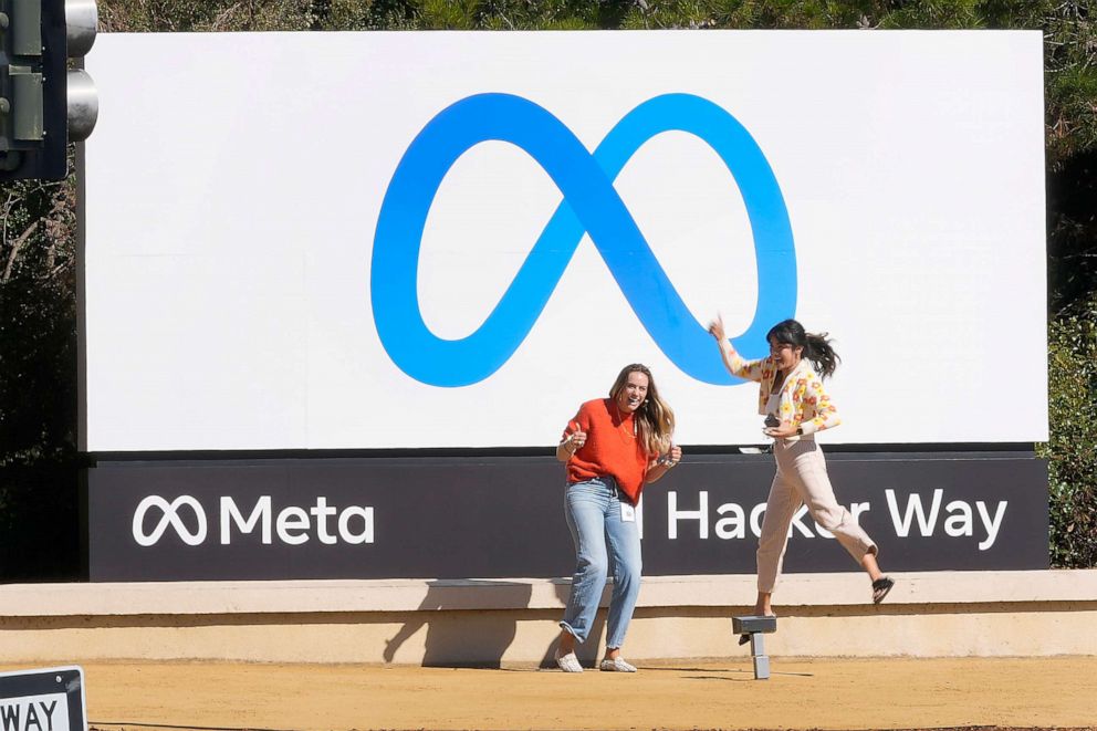 PHOTO: Facebook employees take a photo with the company's new name and logo outside its headquarters in Menlo Park, Calif., Oct. 28, 2021.