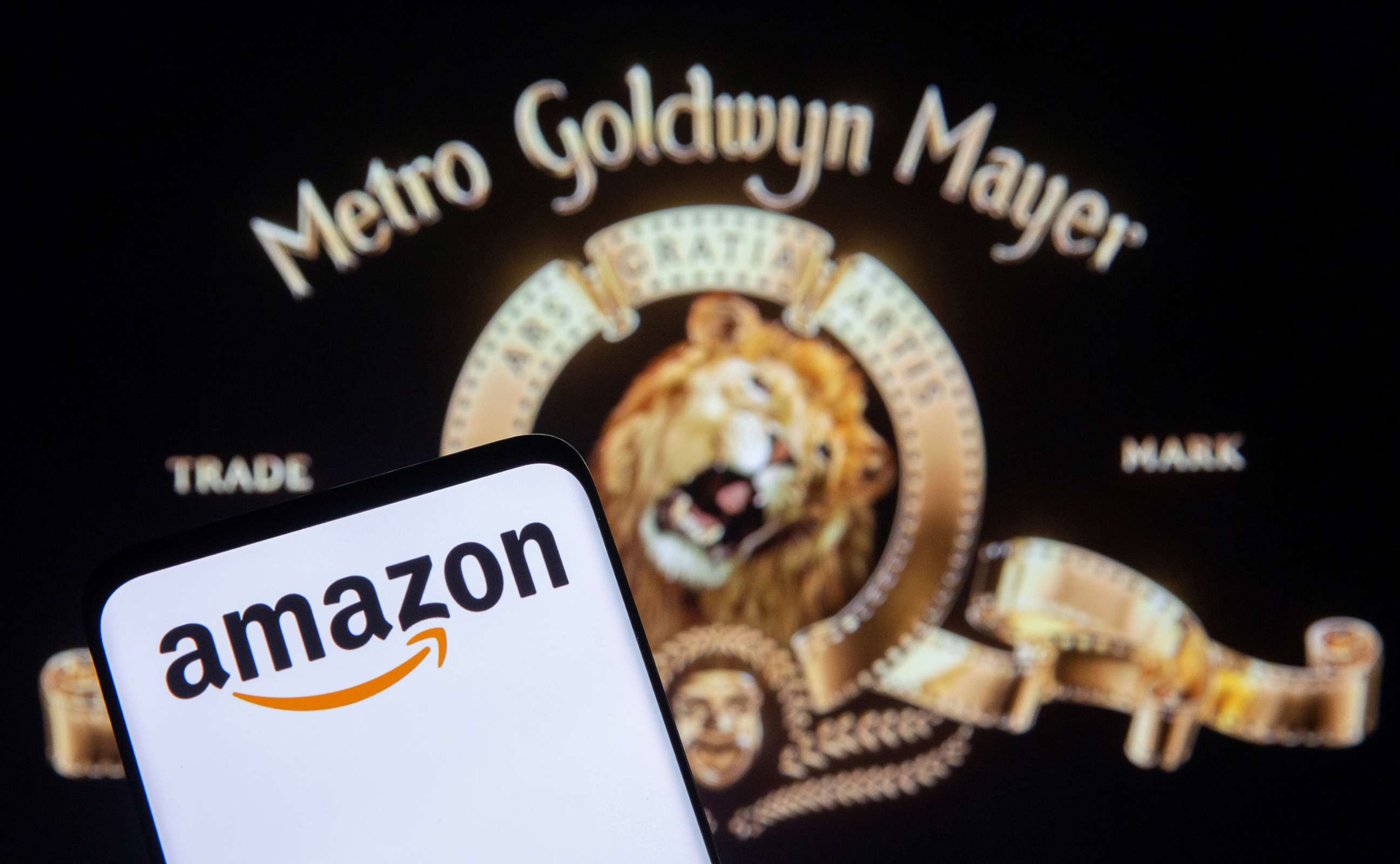 PHOTO: A smartphone with an Amazon logo is seen in front of displayed MGM logo in this illustration taken, May 26, 2021.