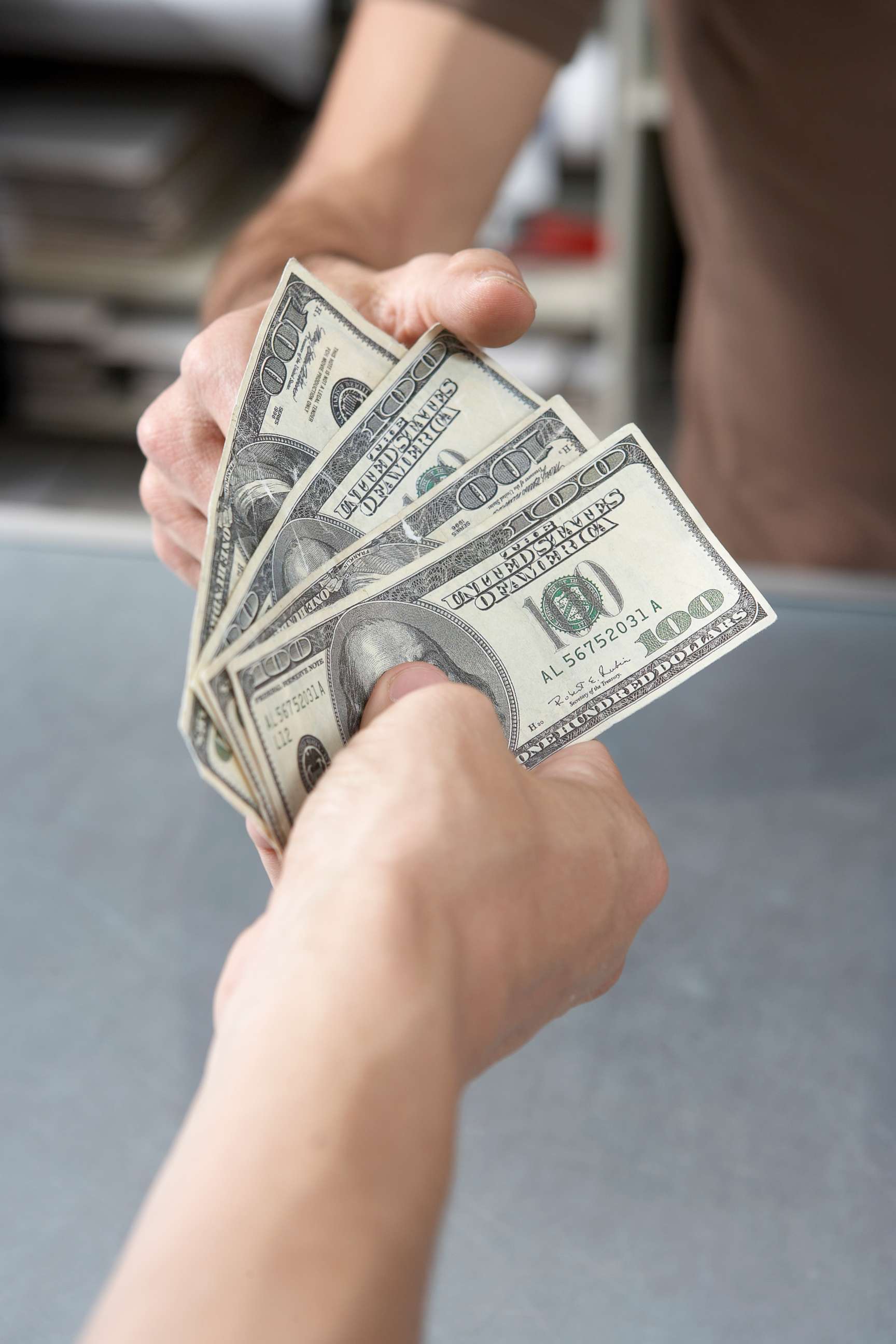 PHOTO: A man hands cash to another person in an undated stock photo.